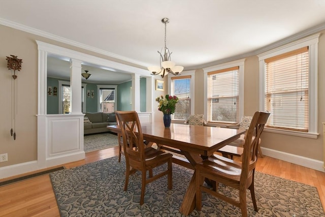 28 Fletcher St Unit 1, Boston, MA 02131 - dining space with ornamental molding, a chandelier, baseboards, light wood-style flooring, and ornate columns