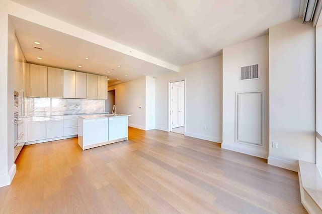 kitchen with light countertops, open floor plan, visible vents, and modern cabinets