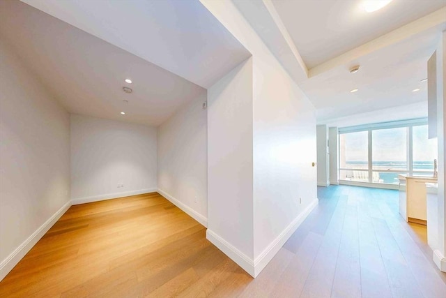 hall with baseboards, recessed lighting, and light wood-style floors