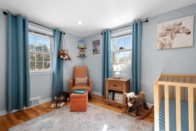 sitting room with visible vents, baseboards, and wood finished floors