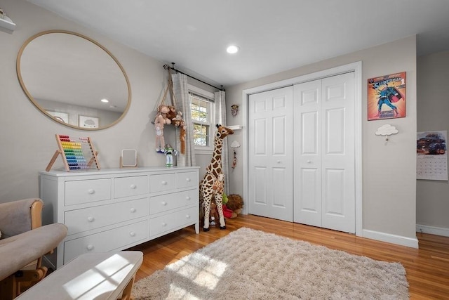 bedroom featuring a closet, recessed lighting, light wood-type flooring, and baseboards