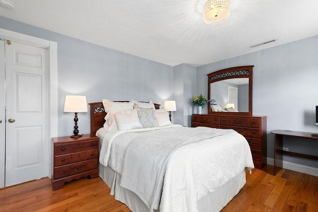 bedroom with visible vents and light wood-type flooring