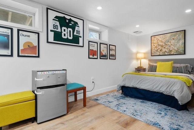 bedroom featuring visible vents, wood finished floors, freestanding refrigerator, recessed lighting, and baseboards