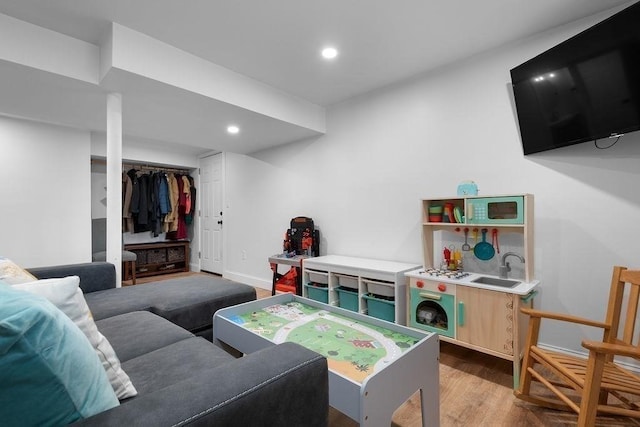 living area with recessed lighting, baseboards, and wood finished floors