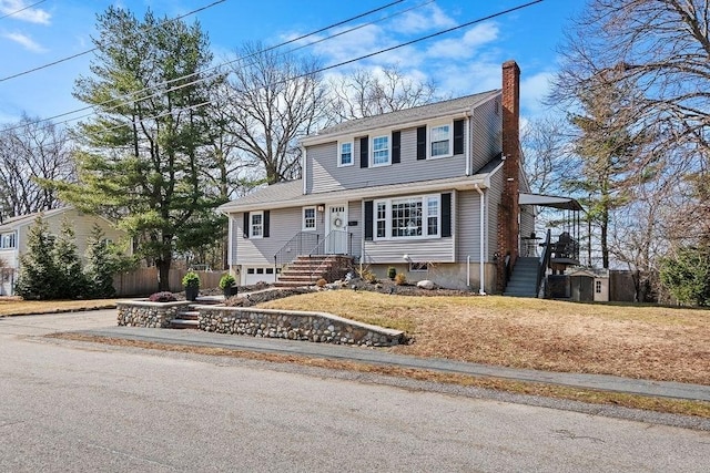 colonial-style house with aphalt driveway, a carport, and a chimney