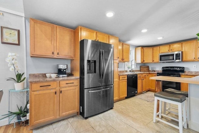 kitchen featuring a sink, black appliances, and recessed lighting