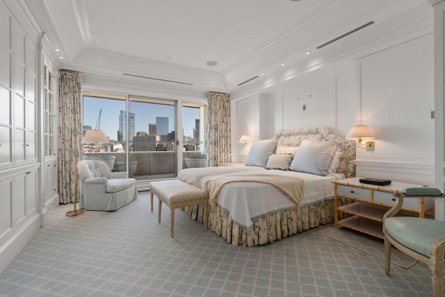 bedroom with a tray ceiling, access to exterior, crown molding, carpet, and a decorative wall