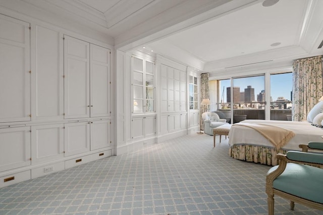 carpeted bedroom with a view of city, ornamental molding, a decorative wall, and access to outside