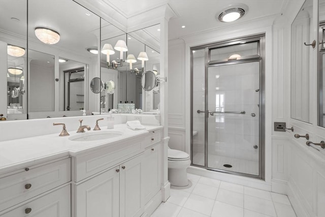 bathroom with vanity, toilet, tile patterned floors, ornamental molding, and a stall shower