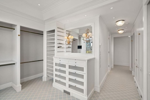 spacious closet featuring a notable chandelier and light colored carpet
