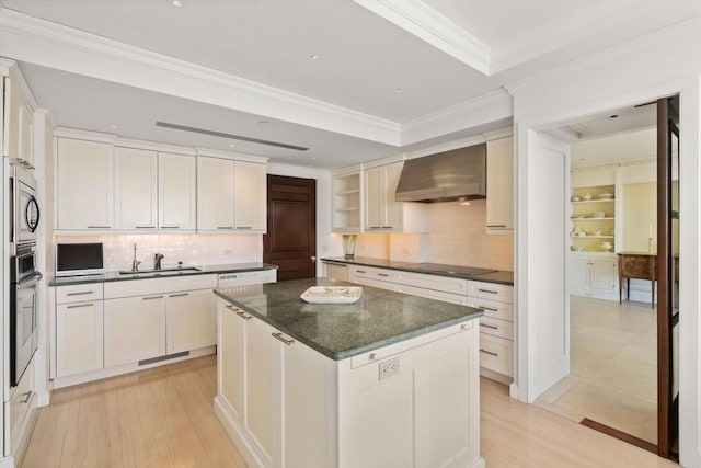 kitchen featuring backsplash, appliances with stainless steel finishes, a sink, and wall chimney exhaust hood