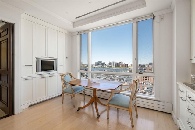 dining room with light wood-style floors, ornamental molding, and floor to ceiling windows