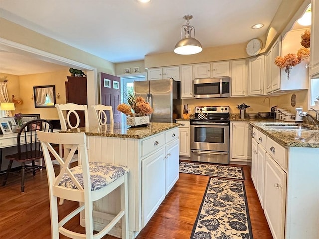 19 Orange Rd, Northfield, MA 01360 - kitchen with appliances with stainless steel finishes, a center island, a kitchen breakfast bar, white cabinetry, and dark wood-style flooring