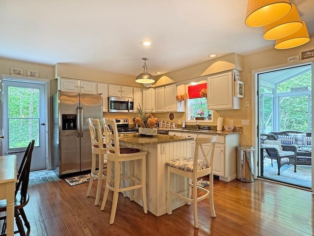 19 Orange Rd, Northfield, MA 01360 - kitchen with stainless steel appliances, dark wood-type flooring, a center island, dark stone counters, and a kitchen bar