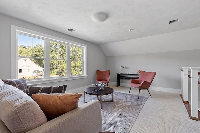 sitting room with lofted ceiling, visible vents, carpet flooring, an upstairs landing, and baseboards