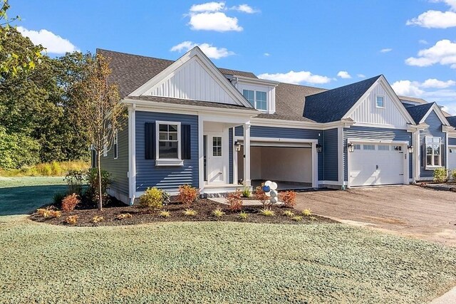 view of front of house with a garage, driveway, board and batten siding, and a front yard