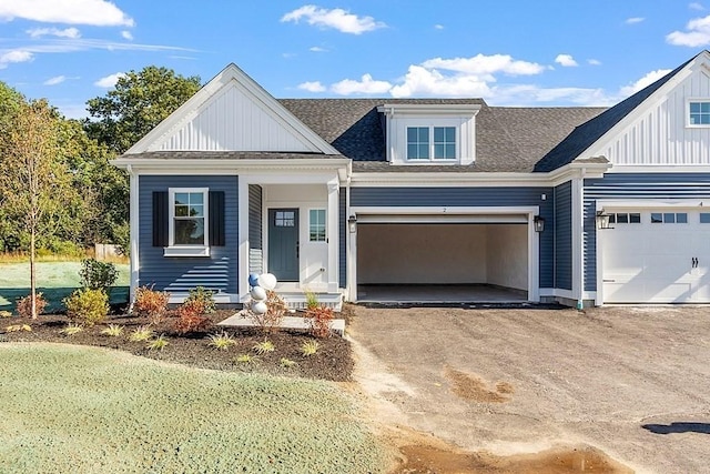 view of front of property with a garage, dirt driveway, board and batten siding, and roof with shingles