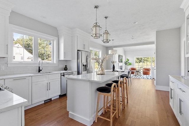 kitchen featuring tasteful backsplash, stainless steel appliances, a sink, and open floor plan