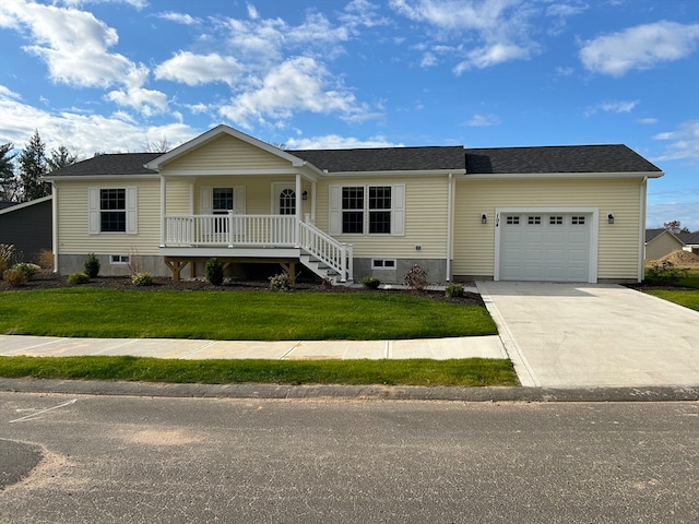 view of front of home with covered porch, a garage, and a front lawn