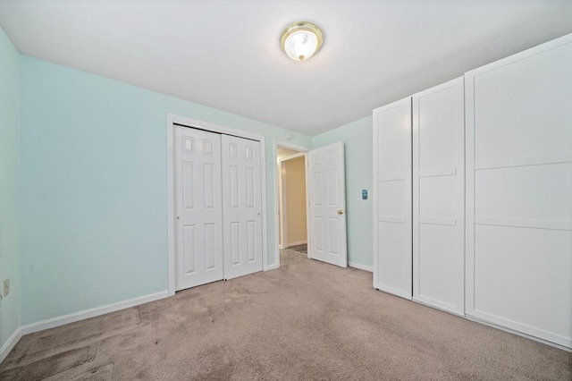 unfurnished bedroom with a closet and light carpet