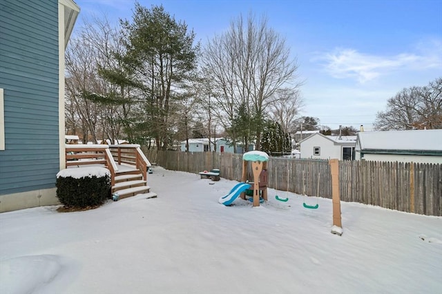 yard covered in snow with a playground