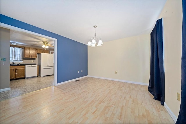 interior space with sink, light wood-type flooring, and ceiling fan with notable chandelier