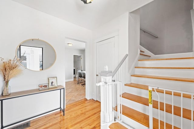 stairway with visible vents and wood finished floors