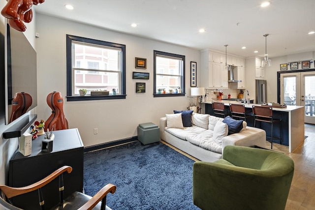 living area featuring recessed lighting, baseboards, light wood-style flooring, and french doors