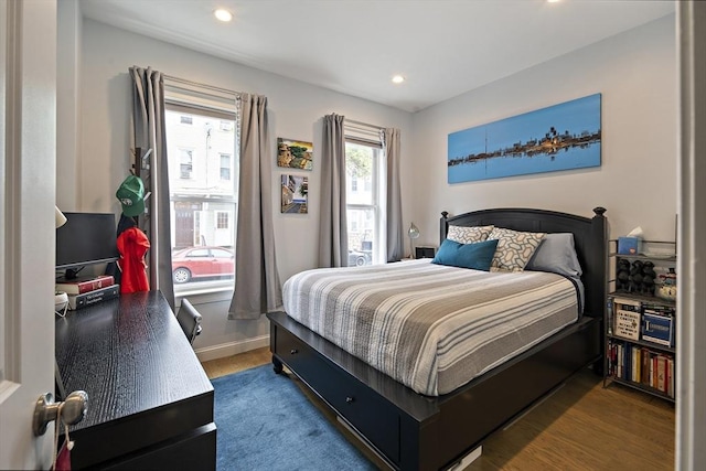 bedroom featuring wood finished floors, recessed lighting, and baseboards