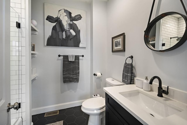bathroom with toilet, tile patterned flooring, vanity, and baseboards