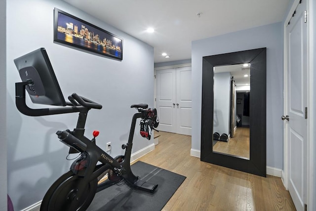 workout room featuring wood finished floors, baseboards, and recessed lighting