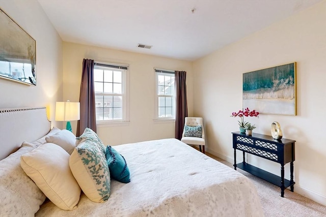 carpeted bedroom with visible vents and baseboards