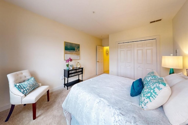 bedroom with baseboards, a closet, visible vents, and light colored carpet