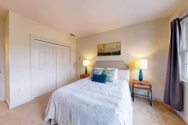 bedroom with carpet floors, a closet, visible vents, and baseboards