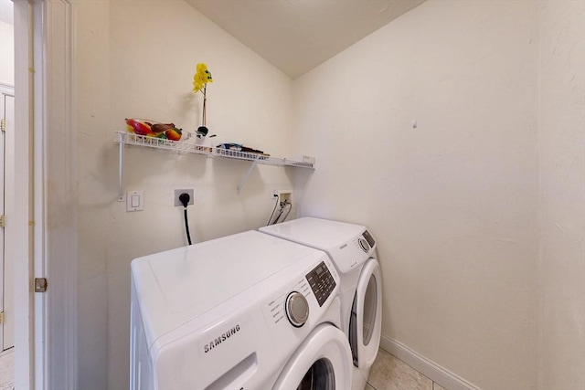 laundry room with laundry area, baseboards, washer and clothes dryer, and light tile patterned flooring