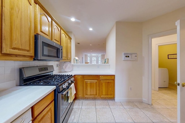 kitchen featuring light tile patterned floors, recessed lighting, light countertops, decorative backsplash, and appliances with stainless steel finishes