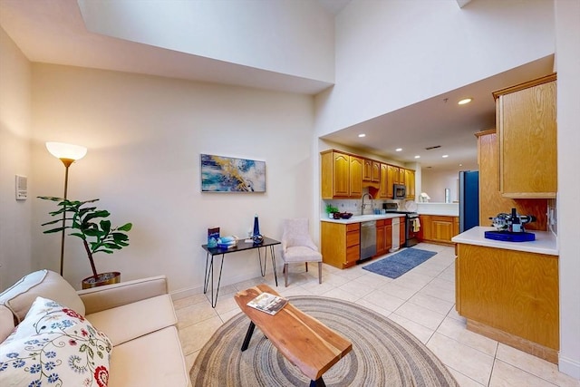 living area featuring recessed lighting, baseboards, light tile patterned flooring, and a high ceiling