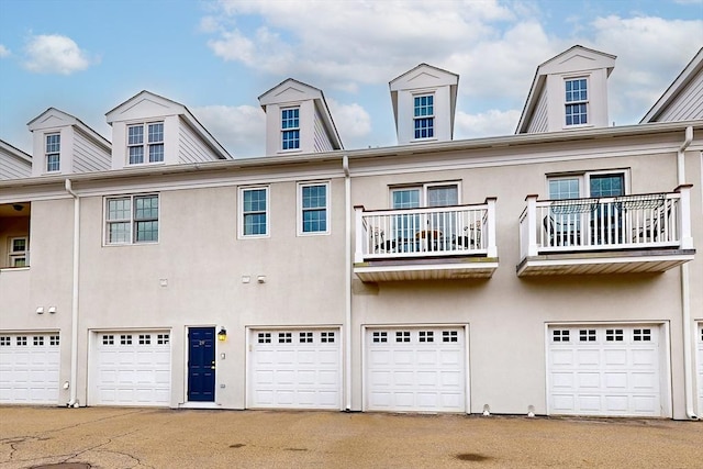 back of house featuring an attached garage and stucco siding