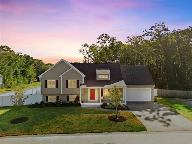 view of front of home featuring aphalt driveway, an attached garage, a front lawn, and fence