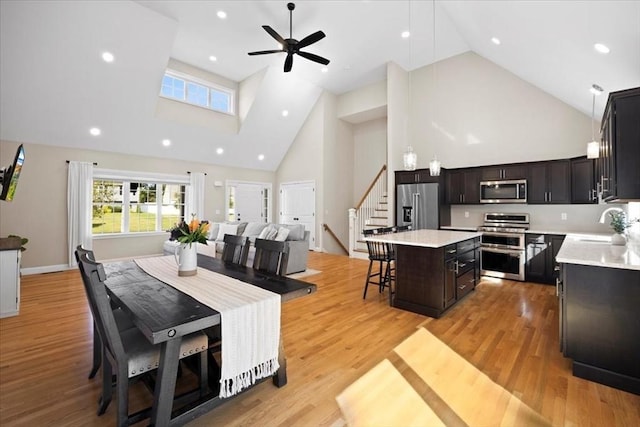 kitchen featuring a kitchen bar, high end appliances, light wood-style floors, and a kitchen island