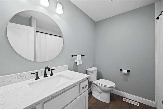 full bath featuring vanity, wood finished floors, visible vents, baseboards, and toilet