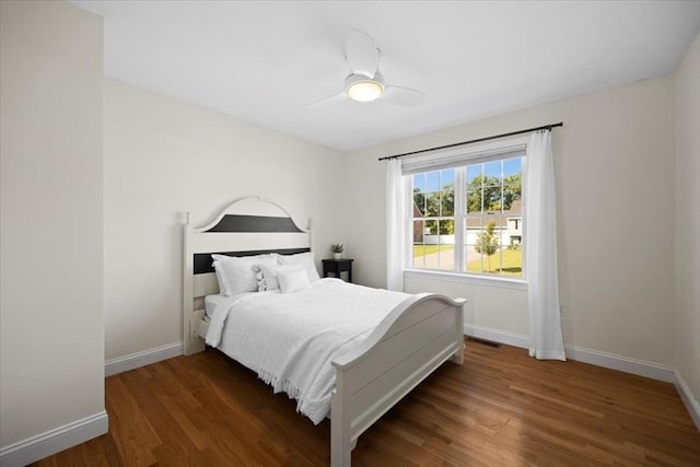 bedroom featuring a ceiling fan, visible vents, wood finished floors, and baseboards