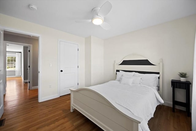 bedroom featuring visible vents, baseboards, wood finished floors, and a ceiling fan