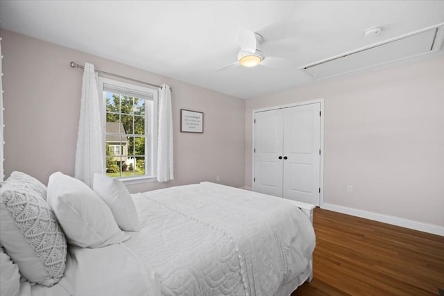 bedroom with baseboards, attic access, ceiling fan, dark wood-type flooring, and a closet