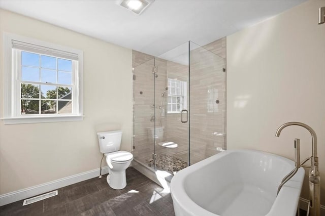 full bathroom featuring visible vents, toilet, a stall shower, baseboards, and a soaking tub