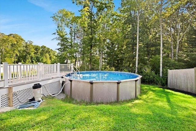 pool with a lawn, a deck, and fence