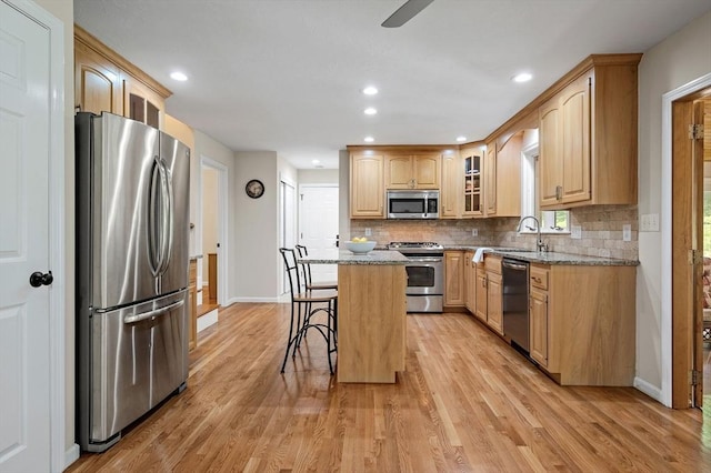 14 Nourse St, Westborough, MA 01581 - kitchen with stainless steel appliances, glass insert cabinets, light stone counters, a kitchen breakfast bar, and tasteful backsplash