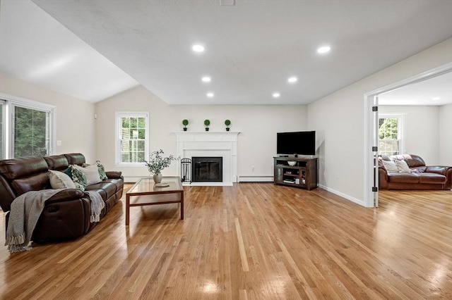 14 Nourse St, Westborough, MA 01581 - living room featuring a baseboard heating unit, light wood-style floors, a glass covered fireplace, recessed lighting, and vaulted ceiling