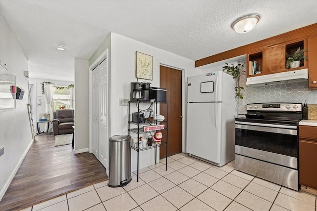 837 Partridgeville Rd Unit 2B, Athol, MA 01331 - kitchen with freestanding refrigerator, stainless steel electric range, under cabinet range hood, decorative backsplash, and light tile patterned floors