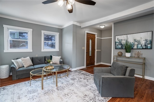 living room with ornamental molding, dark wood-type flooring, and ceiling fan